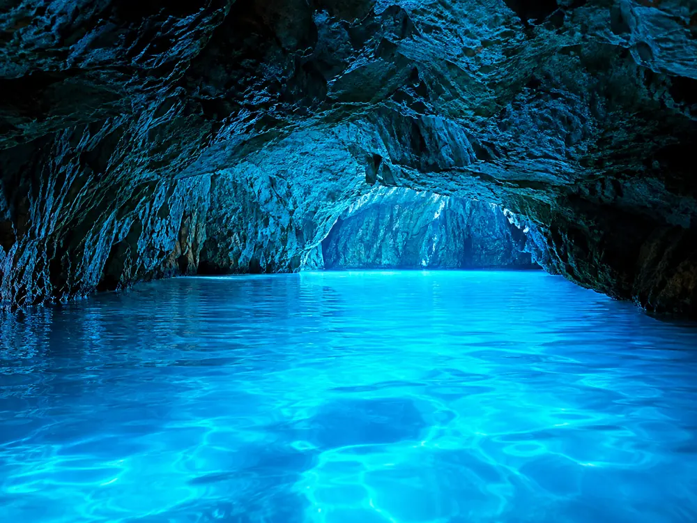 Das Innere einer Meeresgrotte, die von unter der Wasserlinie blau beleuchtet wird